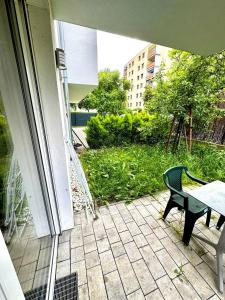un patio con una mesa y un banco en un porche en Cozy 2BR Apartment In Floridsdorf Area, en Viena