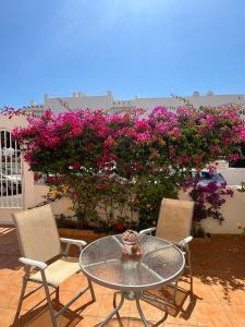 a patio with a table and chairs and flowers at Duplex en urbanización con piscina comunitaria y wifi in Mojácar +18 photos