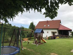 a playground in a yard with a house at Apartments Renata in Smoljanac
