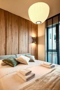 a bedroom with a large bed with two towels on it at Nook in Timişoara