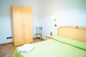 a bedroom with a bed and a chair and a table at Le Tartarughe Aparthotel in Letojanni