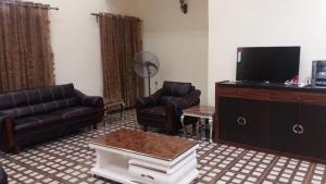 a living room with a couch and a tv at FOA Residence in Warri