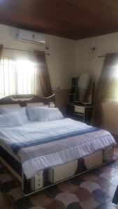 sypialnia z dużym łóżkiem i lustrem w obiekcie FOA Residence w Warri