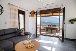 a living room with a couch and a table at Archontiki Veranda - Design Villa in Crete with Heated Pool, Jacuzzi & Dreamy Views in Arkhondikí