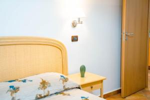 a bedroom with a bed and a table with a lamp at Le Tartarughe Aparthotel in Letojanni
