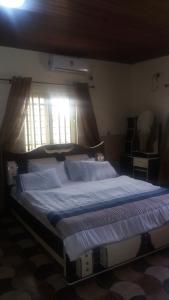 1 cama grande en un dormitorio con ventana en FOA Residence, en Warri