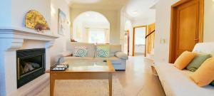 un salon avec un canapé et une cheminée dans l'établissement Algarver I - Boavista Golf Fairview SwimPool Villa, à Lagos