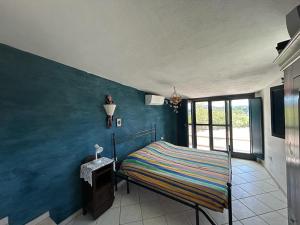 a bedroom with a bed with a blue wall at Villa CHIA in Chia