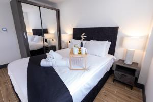 a bedroom with a bed with a night stand on it at Brand-New Borehamwood 1-Bed, 1-Bath Flat in Borehamwood