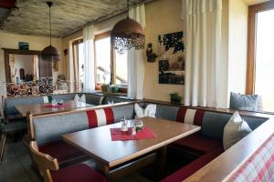 a restaurant with two tables and benches and windows at Pension Spreitzhof & Appartement Royer in Schladming