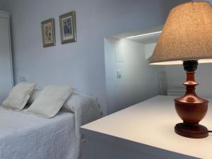 a lamp sitting on a table next to a bed at Mirador al puente del río Genil in Puente-Genil