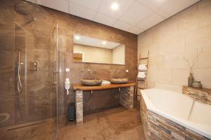 a bathroom with two sinks and a tub at Hotel De Vrouwe van Stavoren in Stavoren