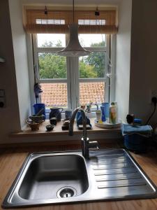 a kitchen with a sink and a window at Lejlighed nær badesø in Årslev