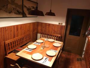 a wooden table with plates and chopsticks on it at MaxDan Lodge in Kranjska Gora +11 photos