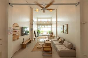 ein Wohnzimmer mit Sofa und Tisch in der Unterkunft TIDE & TRIBE HOSTEL Phangan in Thongsala