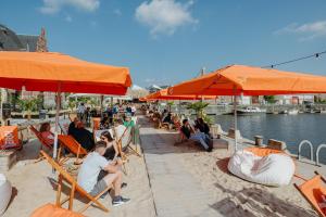 a group of people sitting in chairs under umbrellas at Van der Valk Hotel Mechelen in Mechelen