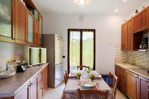 a kitchen with a table with chairs and a refrigerator at Casa Vacanze Marì E Françe in Dolcedo