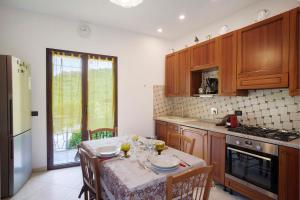 a kitchen with a table with chairs and a tableablish at Casa Vacanze Marì E Françe in Dolcedo +14 photos
