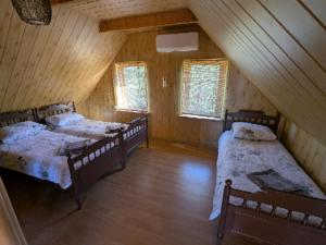 a attic room with three beds and two windows at Trevena Endriejavas in Endriejavas