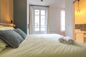 Un dormitorio con una gran cama blanca con toallas. en 4 Guest - Hausmanian Flat Arc de Triomph, en París
