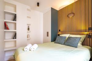 Un dormitorio con una cama con almohadas azules y blancas. en 4 Guest - Hausmanian Flat Arc de Triomph, en París 10 fotos más