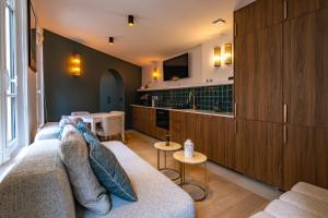 Una sala de estar con un sofá y una cocina. en 4 Guest - Hausmanian Flat Arc de Triomph, en París