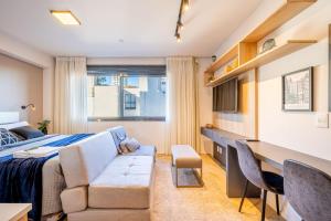Un dormitorio con una cama, un sofá y un escritorio. en Lucas by Yoo por LikeHome, en Auxiliadora