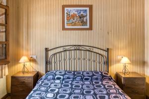 Un dormitorio con una cama grande con dos mesitas de noche. en Cal Ferrer 2 - Quadres, en Torroella de Fluvià