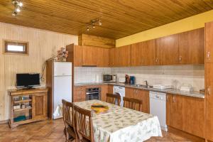 Una cocina con una mesa y un refrigerador blanco. en Cal Ferrer 2 - Quadres, en Torroella de Fluvià