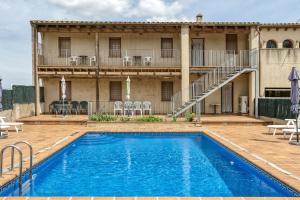 una piscina frente a un edificio con patio en Cal Ferrer 2 - Quadres, en Torroella de Fluvià