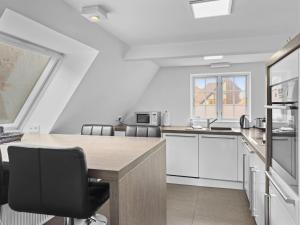 cocina blanca con mesa de madera y sillas en Objekt-Nr 161 - Hafen - Vorderreihe, en Travemünde