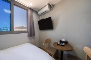 a room with a bed and a table and a window at Hongdae Sinchon Theme Motel in Seoul +6 photos