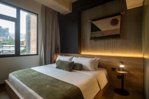 a hotel room with a bed and a window at Hunters Hotel by Jalo in Medellín