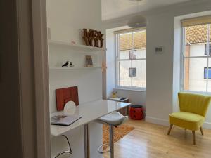 a room with a desk and a chair and two windows at Me and You Sleeps 2 - Central Apartment in Berwick Northumberland in Berwick-Upon-Tweed