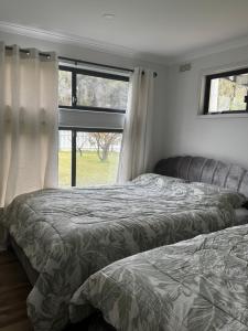 two beds in a bedroom with a window at Teresa Ct in Rye