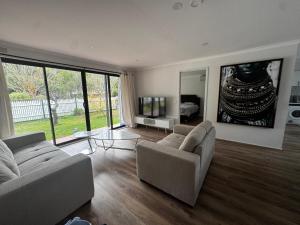 a living room with two couches and a large window at Teresa Ct in Rye
