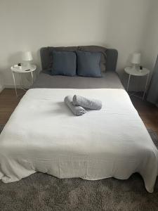 Una cama blanca grande con dos almohadas encima. en Ferme Cosy et Paisible au Bord de l'Eure, en Criquebeuf-sur-Seine