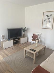 sala de estar con TV y mesa de centro en Ferme Cosy et Paisible au Bord de l'Eure, en Criquebeuf-sur-Seine