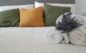 a white bed with a bouquet of flowers on it at Monolocale Portofino in Turin