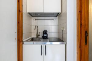 a kitchen with white cabinets and a sink at Panieri Apt - Homkeey Apartments in Rome
