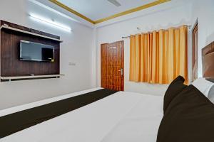 a bedroom with a bed and a tv on the wall at Hotel O RR Palace in Bheta