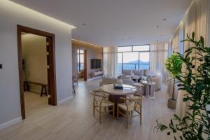 a living room with a table and chairs at Ghazal Hotel in Taif