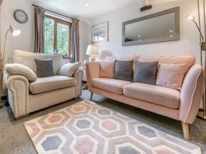 ein Wohnzimmer mit einer Couch und einem Sessel in der Unterkunft Rose Cottage in Hartland