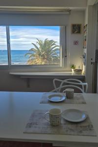 a table with a view of the ocean from a window at Del Santo San Valentín in Puerto Madryn