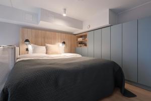 a bedroom with a large bed and white cabinets at Unity Helsinki - A Studio Hotel in Helsinki +34 photos