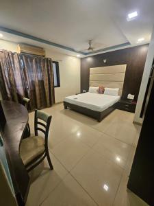 a bedroom with a bed and a chair in it at Prime Hotel Addore Palácée - Near Mumbai Airport , Visa Consultant , Jio World Convention Centre BKC in Mumbai +37 photos