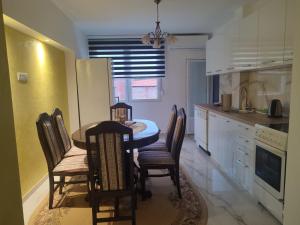 a kitchen with a table and chairs in a room at Apartman Orhideja in Knjazevac.
