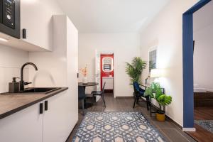 a kitchen and living room with a sink and a table at R10 - Boutique Apartments, Best location by BQA in Budapest