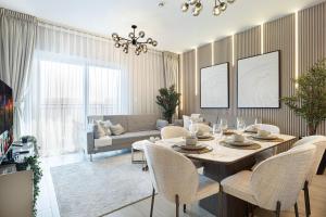 a living room with a table and chairs and a couch at Luxury 4 Bedroom Apartment with Ferrari World and Sea Views, Yas Island Waterfront, Pool, Gym, Playground, Walk to Yas Mall in Abu Dhabi