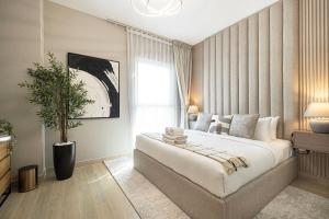 a bedroom with a large bed and a potted plant at Luxury 4 Bedroom Apartment with Ferrari World and Sea Views, Yas Island Waterfront, Pool, Gym, Playground, Walk to Yas Mall in Abu Dhabi